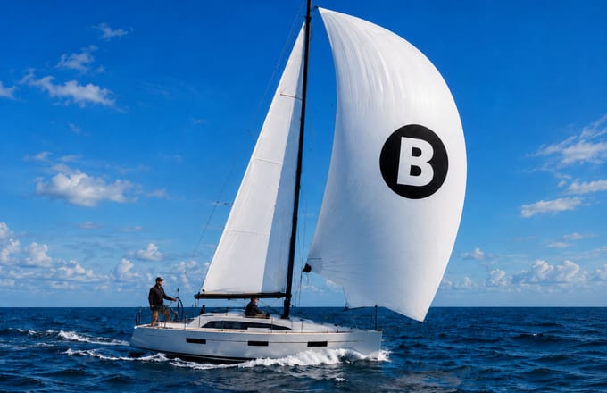 Sailboat under full sail with a Bowire pennant on the mainsail